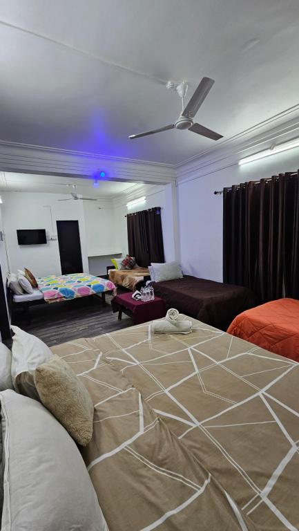 a living room with a bed and a living room with a couch at Hotel Sagar Darbar in Daman