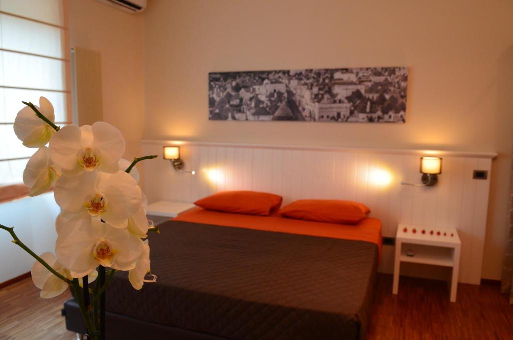 a bedroom with a bed with two pillows and flowers at Terraeccellente B&B in Acquaviva delle Fonti