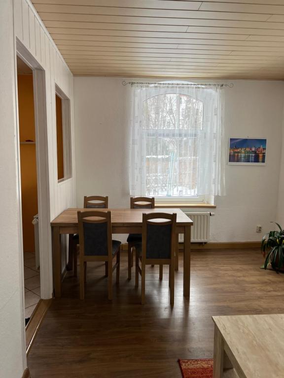 a dining room with a wooden table and chairs at Ferienwohnung in Walddorf