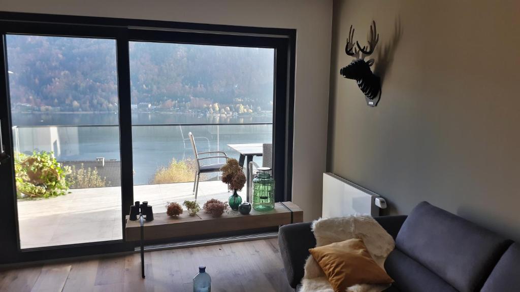a living room with a large window with a view at Ferienhaus Berg'nSee in Annenheim