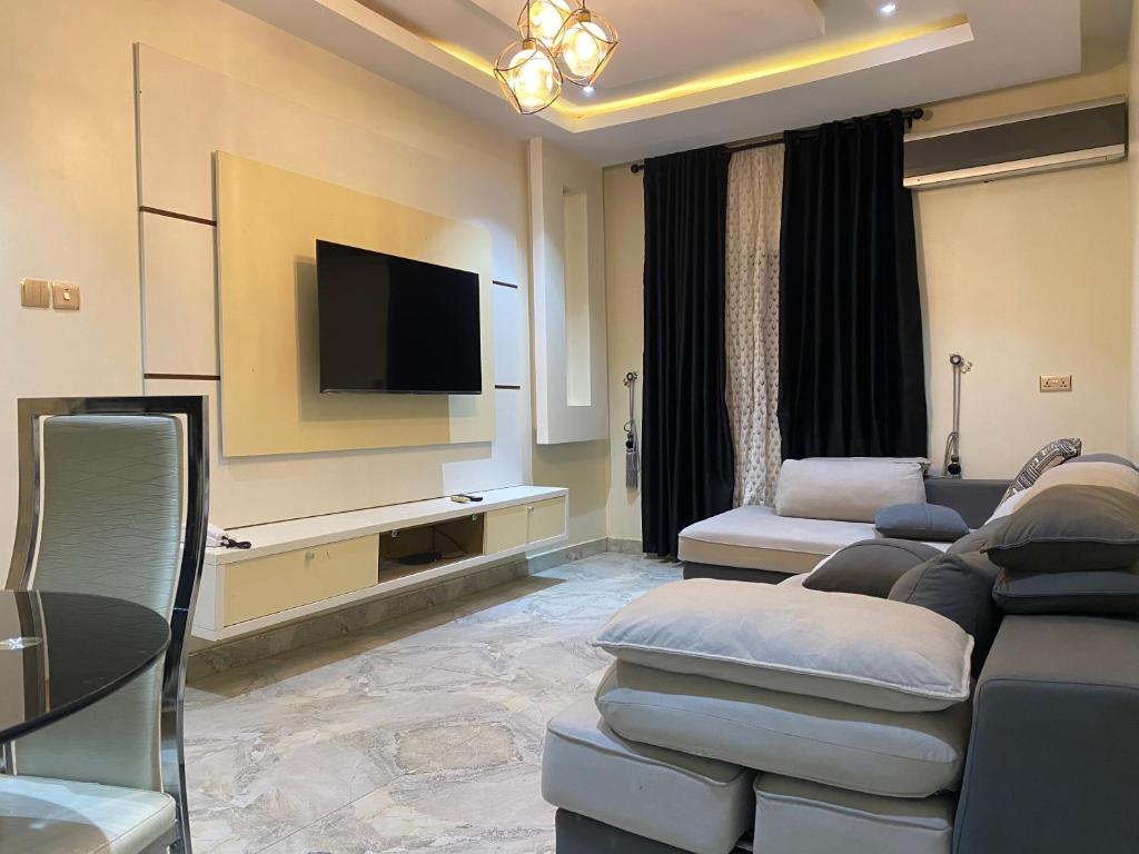 salon z kanapą i telewizorem z płaskim ekranem w obiekcie Zurik Apartments w mieście Kusafe