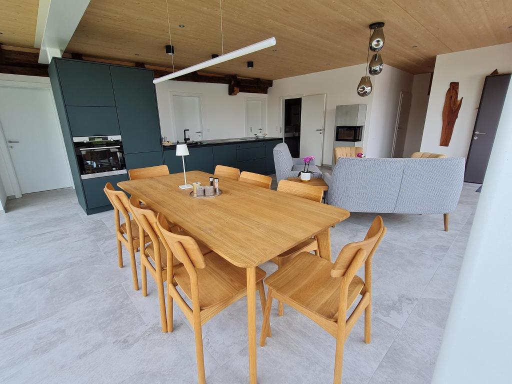 uma sala de jantar com uma mesa de madeira e cadeiras em Luxuriöses Landhaus Kaag 1723 