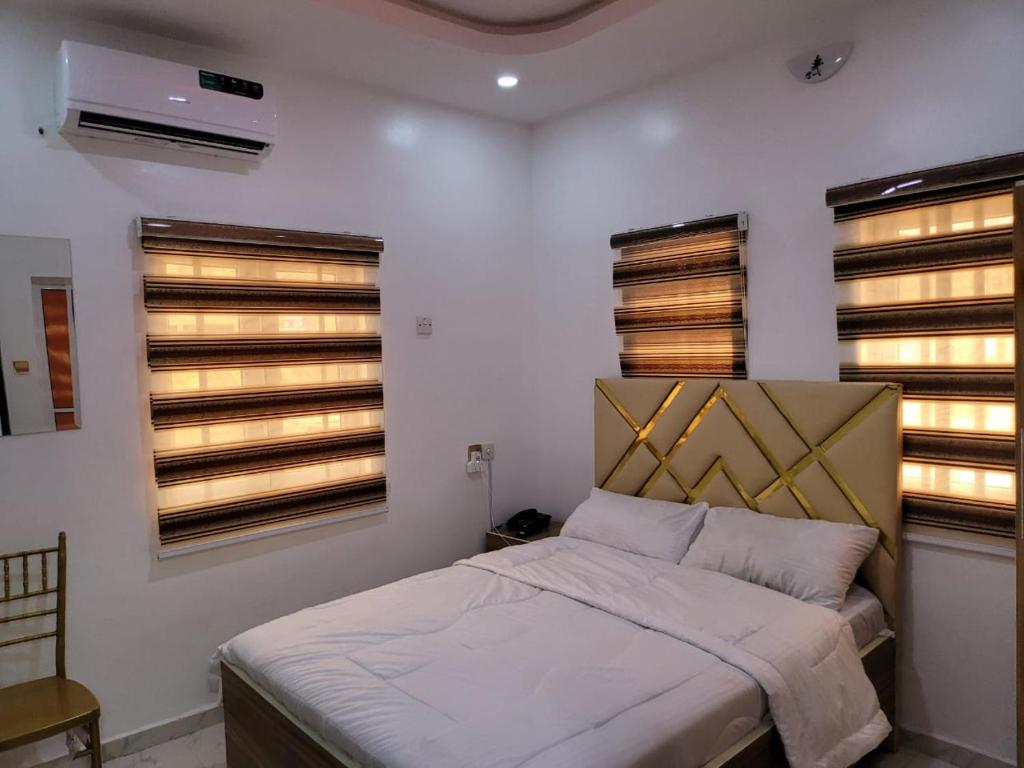 um quarto com uma cama e duas janelas em B&Y ROYAL BAR & LOUNGE ADIGBE ROAD MONIJESU NEAR ADIGBE POLICE STATION em Abeokuta