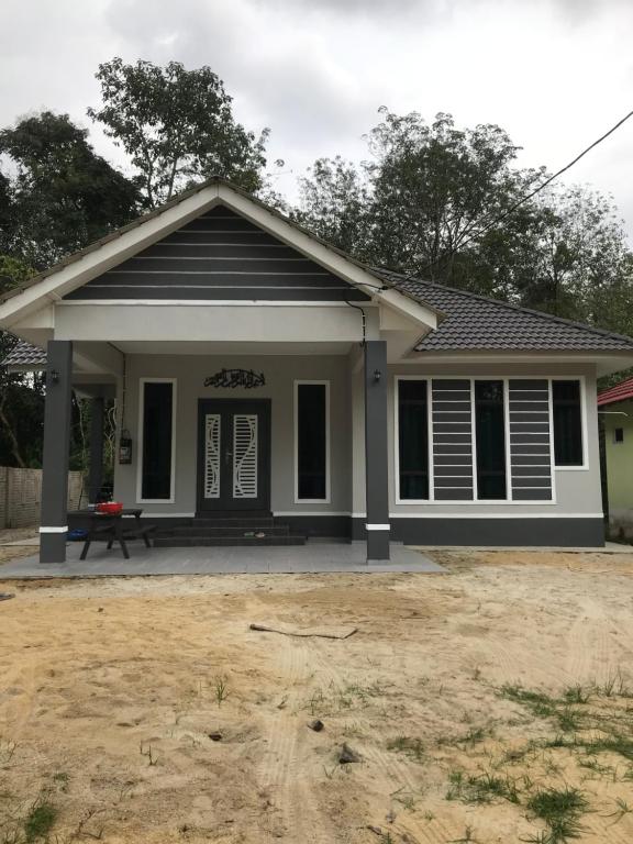 a home with a black and white house at AINUL HOMESTAY in Pasir Mas