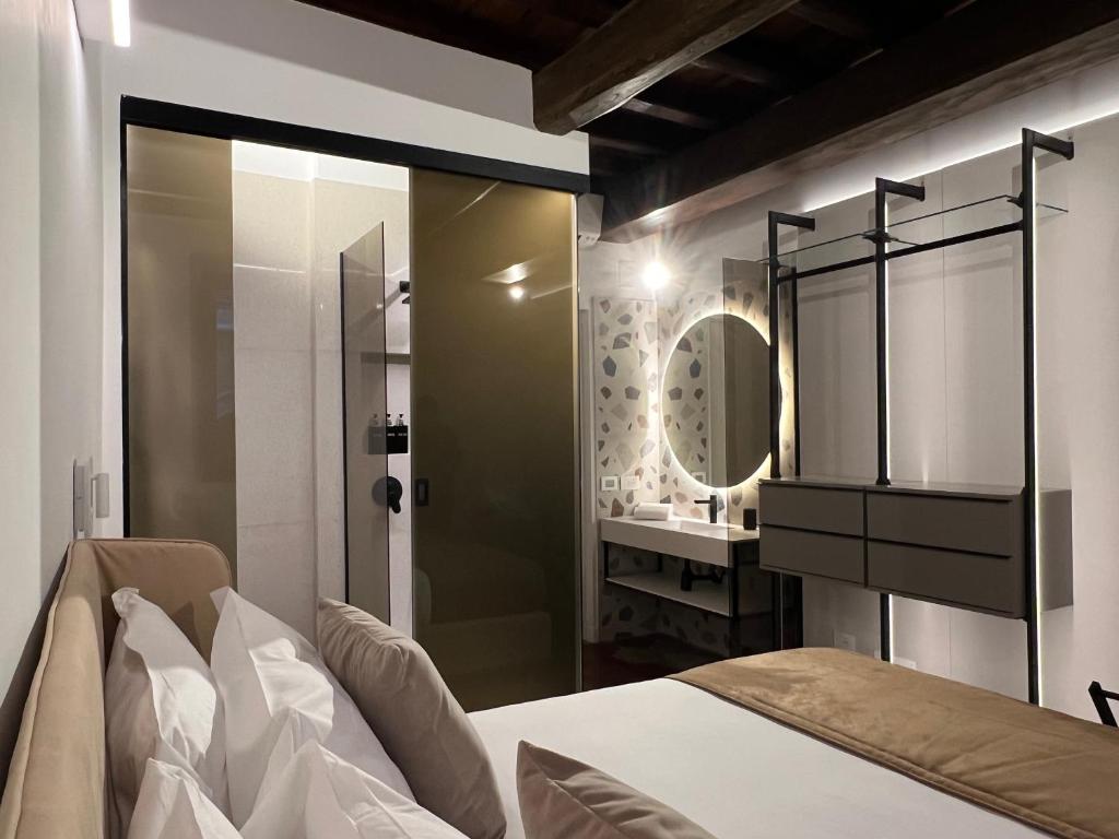 ein Schlafzimmer mit einem Bett und ein Badezimmer mit einem Spiegel in der Unterkunft Affreschi al Pantheon in Rom