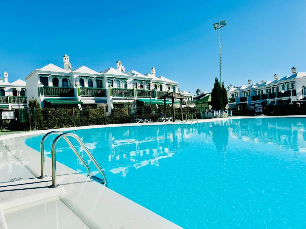una grande piscina di fronte ad alcune case di Casa Dunaflor a Maspalomas
