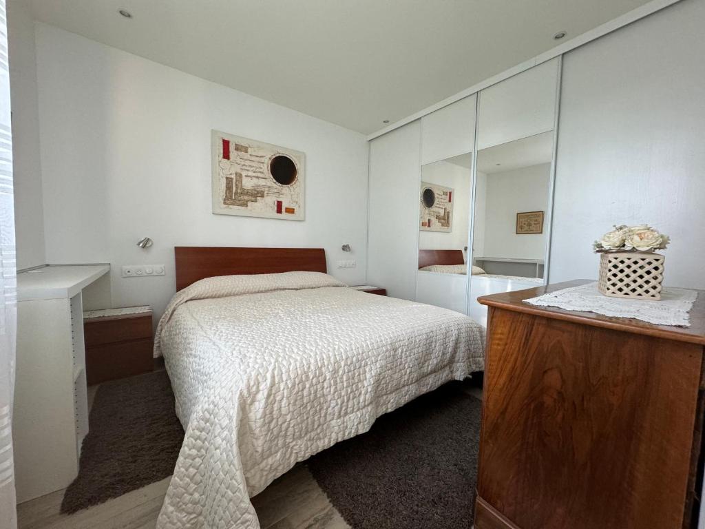 ein weißes Schlafzimmer mit einem Bett und einem Spiegel in der Unterkunft Charmante maison avec terrasse in Auterive