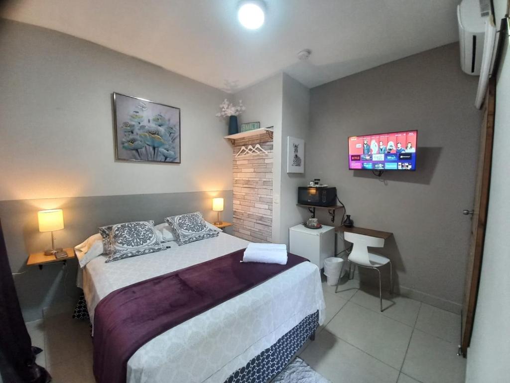 sypialnia z łóżkiem i telewizorem na ścianie w obiekcie Villa San Valentin w mieście San Pedro Sula