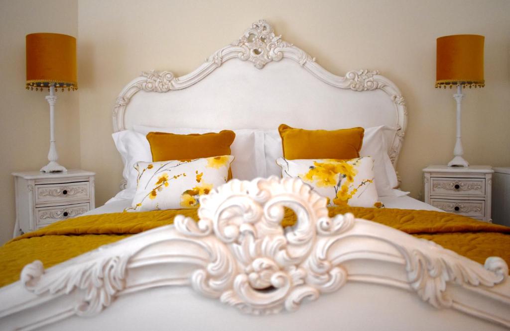 un letto bianco con due comodini e due lampade di WEE SUZIE STAYS - Stunning George St Apartment a Perth