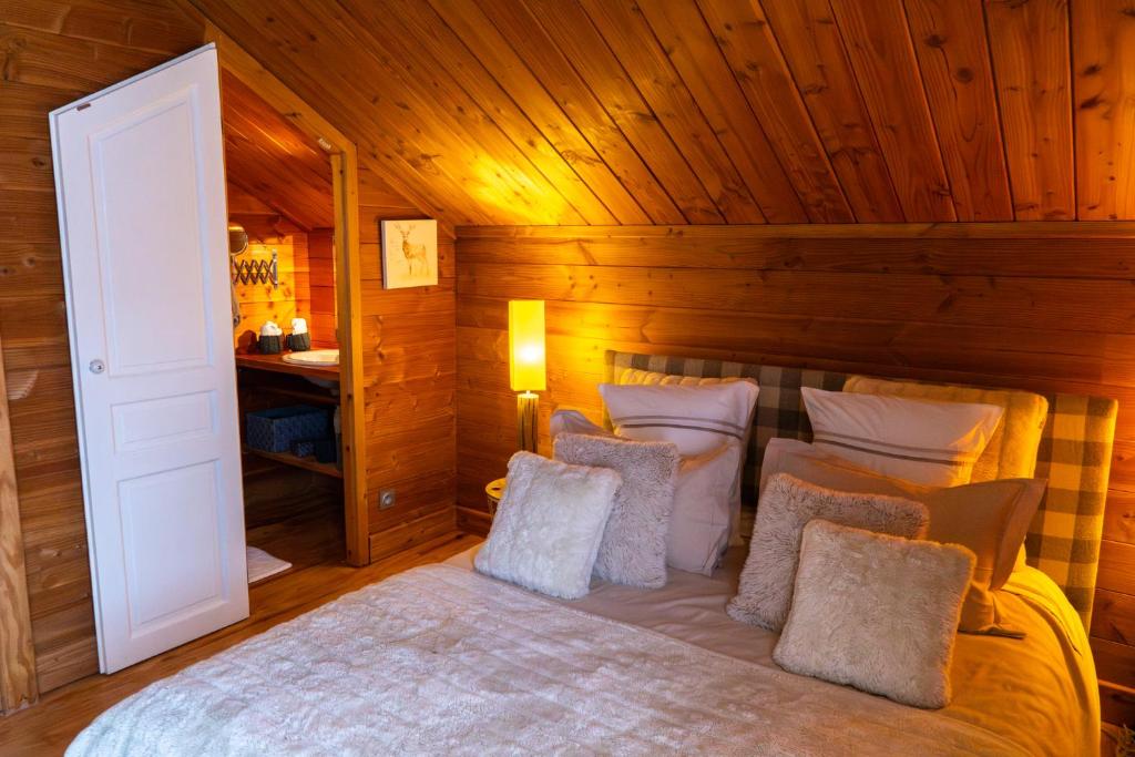a bedroom with a bed with a wooden wall at Chambres et table d'hôtes au chalet Datcha in Briançon