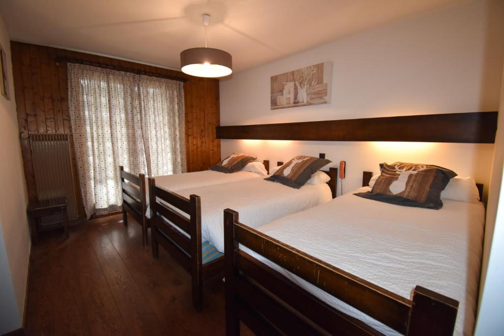 Postel nebo postele na pokoji v ubytování Hôtel Le Chinfrey