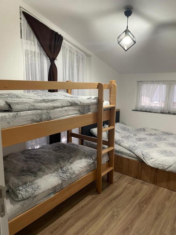 a bedroom with two bunk beds and a window at Woodland Resort Shkrel in Boge
