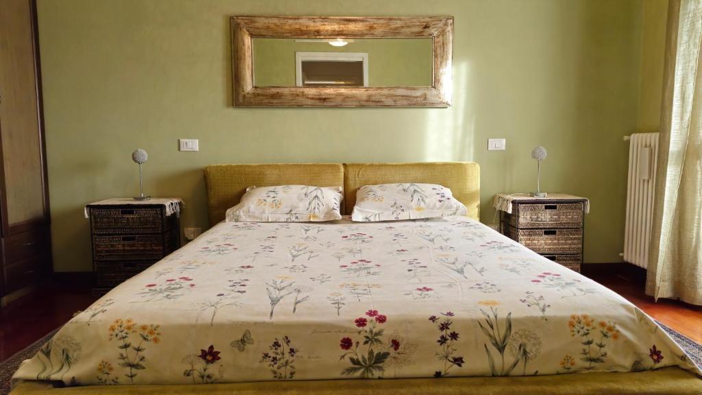 a bed in a bedroom with two night stands and a mirror at Galileo 79 in Ravenna