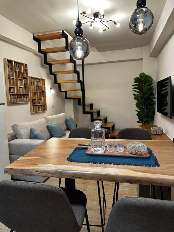sala de estar con mesa y escalera en Mentha Luxury Home, en Lefkogeia