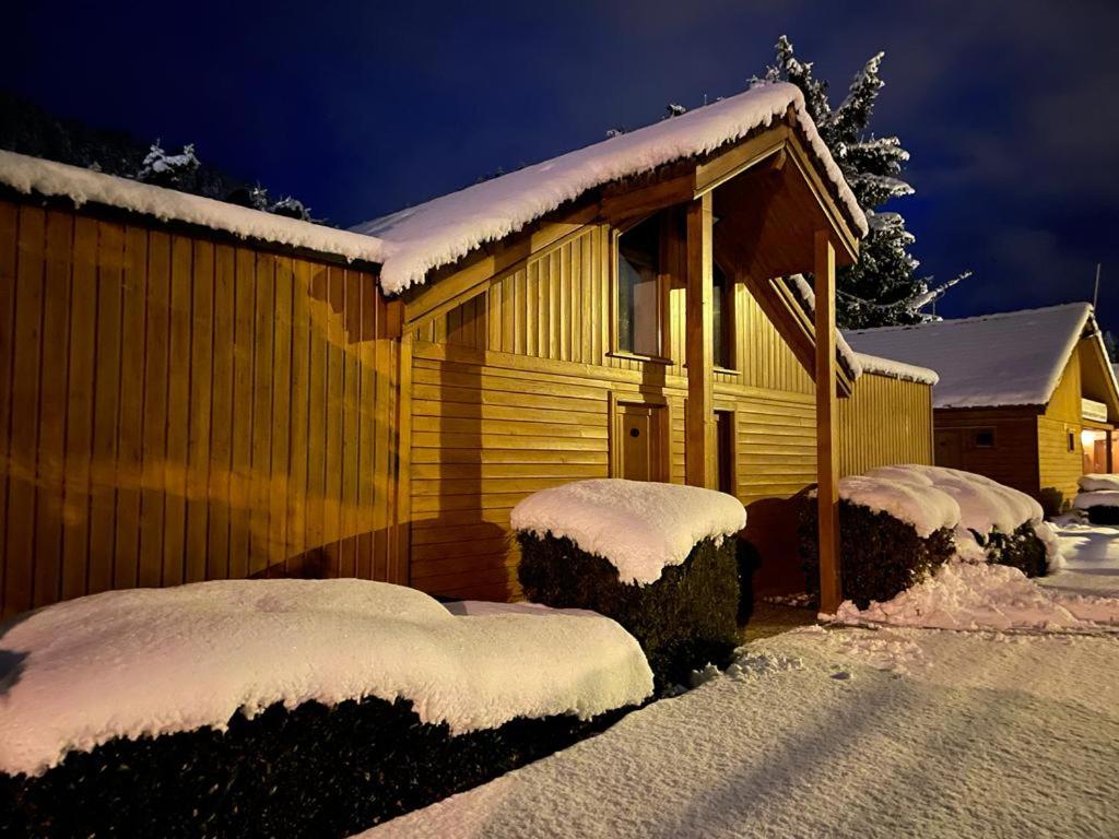 une maison recouverte de neige avec des buissons enneigés dans l'établissement Capucine 1, à Gérardmer