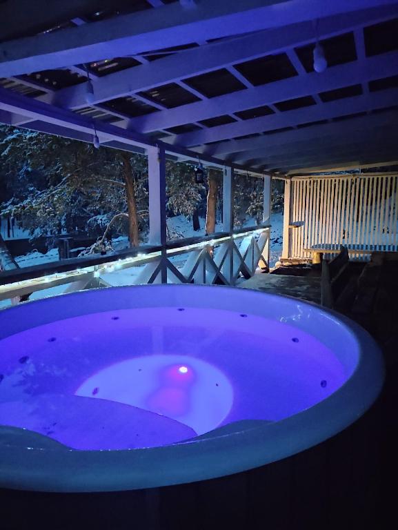 bañera púrpura en una habitación con nieve en Sodyba Valdo kubilas, en Trakai