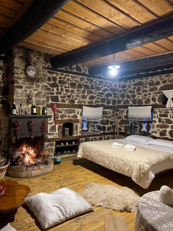 a bedroom with a bed and a fire place at Kulla Hupi Agriturism in Bulqizë