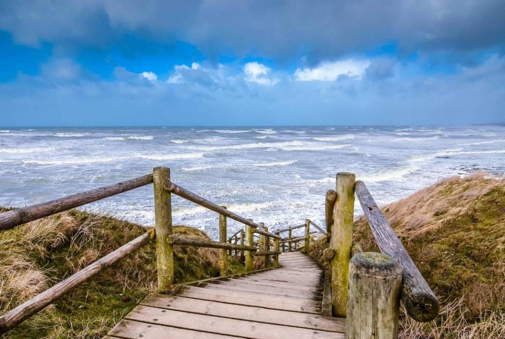 a wooden boardwalk leading to the ocean on a beach at Proche Golf Appartement 4pers avec parking piscine tennis in Neufchâtel-Hardelot