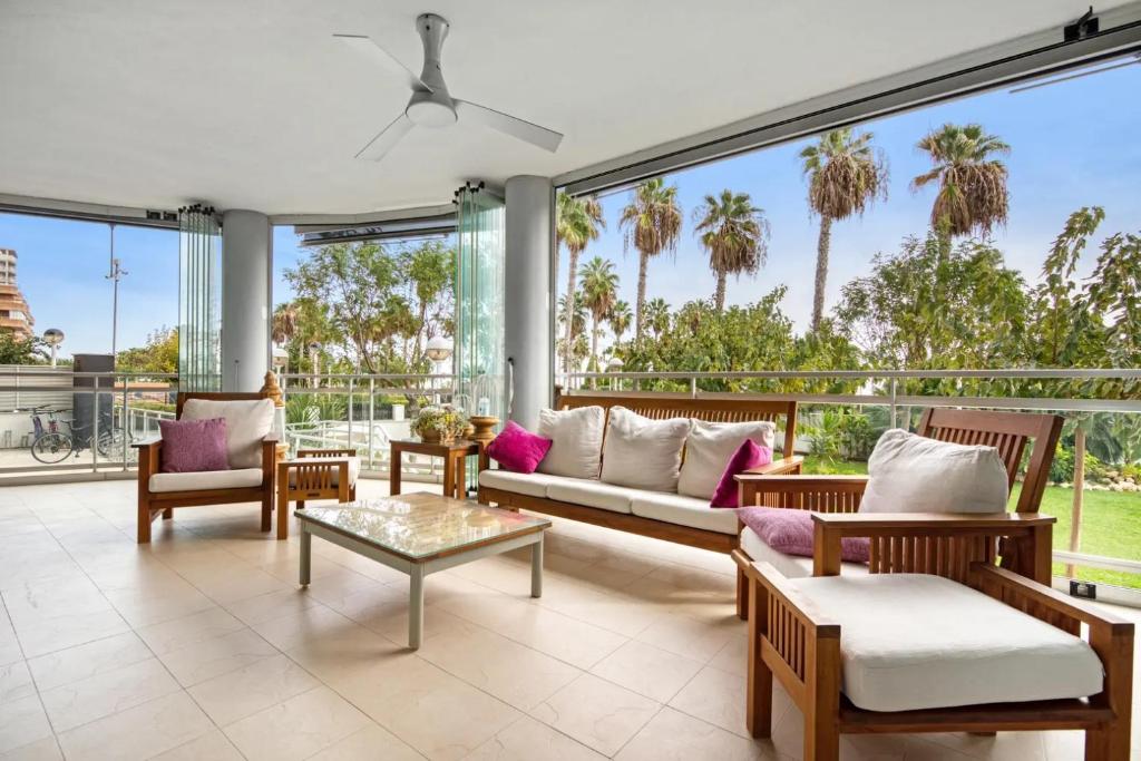 a living room with a couch and chairs and windows at APARTAMENTO CON ESPECTACULAR TERRAZA FRENTE AL MAR in Oropesa del Mar