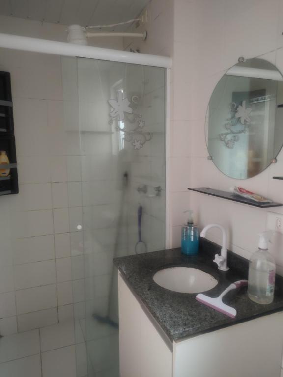 a bathroom with a sink and a shower with a mirror at Veredas do bosque in Curitiba