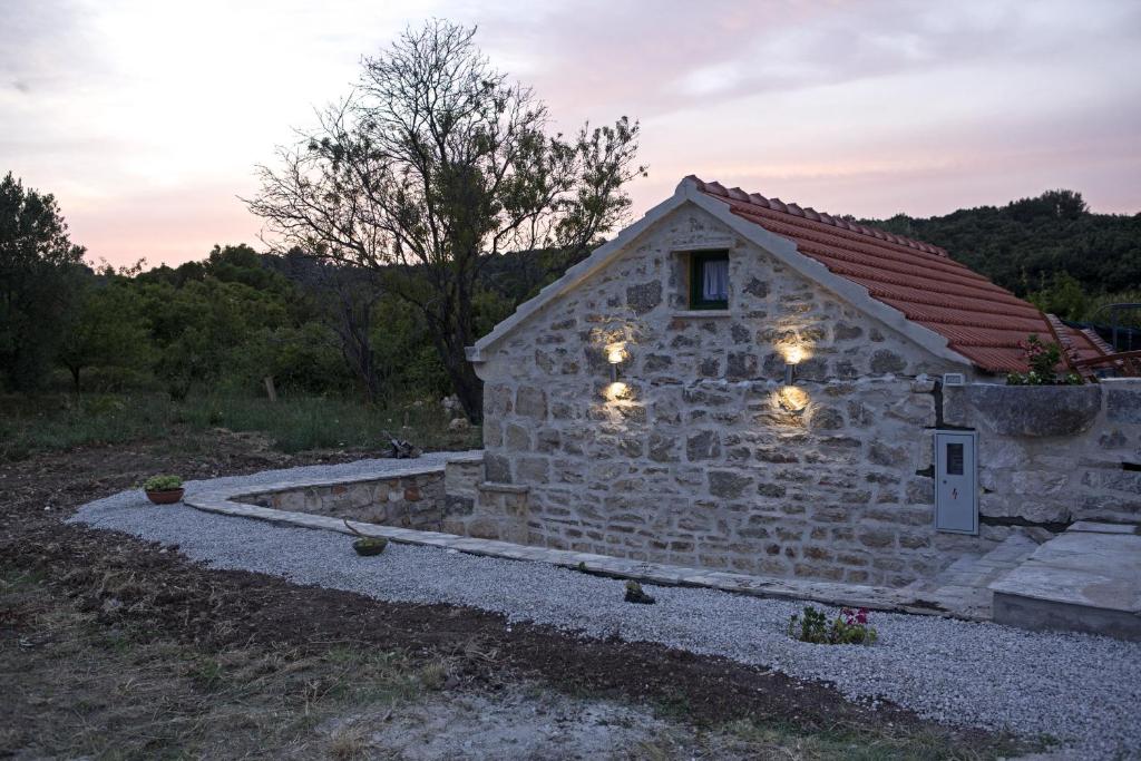 un edificio de piedra con luces en el lateral. en Country House Vinko, en Račišće