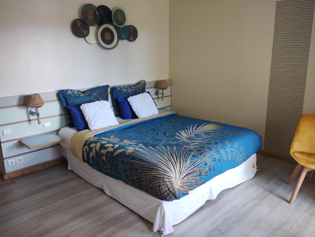 een slaapkamer met een bed met een blauw dekbed bij Charmant T1 avec vue sur marina in Les Trois-Îlets