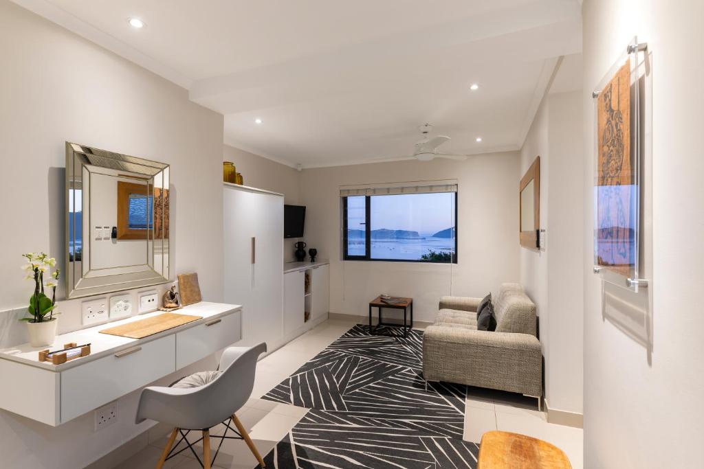 a living room with a couch and a chair at THEBLOEM Guest Suites by Knysna Paradise Collection in Knysna