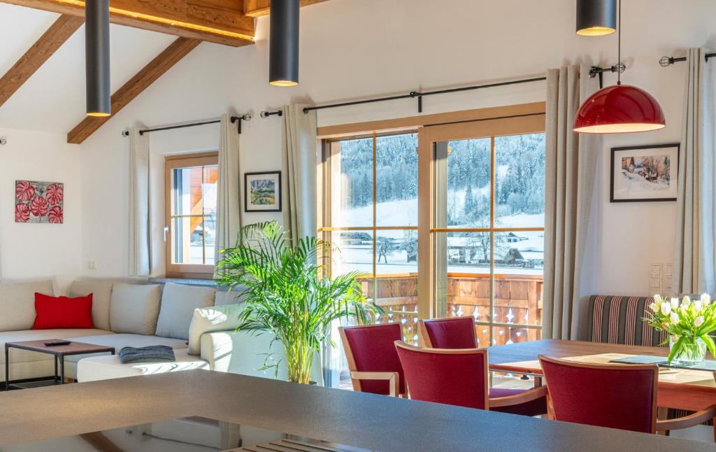 a living room with a table and chairs and windows at Villa Elisabeth in Strobl