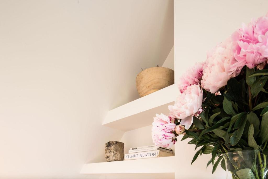 wazon różowych kwiatów na półce w obiekcie Bed & Breakfast Karakter w mieście Den Dungen