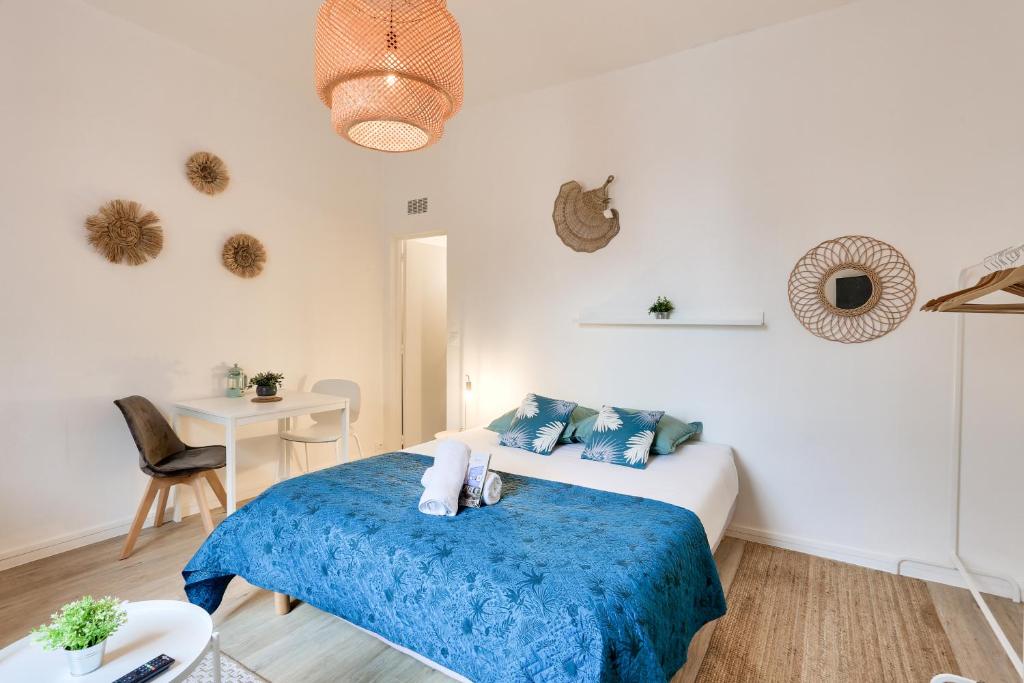 une chambre avec un lit avec une couverture bleue dans l'établissement Charmant Studio proche parc du Thabor et centre, à Rennes