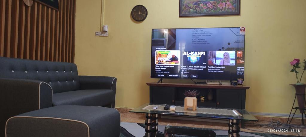 a waiting room with a tv and a chair and a table at HOMESTAY ALORSETAR TOWNCENTRE by ASTARILA GUESTHOUSE-StadiumDarulaman - iSLAM SAHAJA - Private Pool, BBQ Zone & Kolam Pancing Puyu - 8-13pax in Alor Setar
