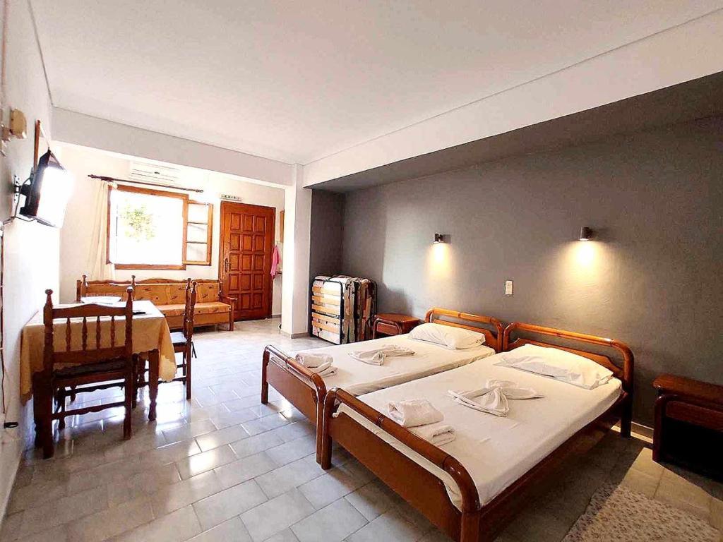 - une chambre avec 2 lits, une table et des chaises dans l'établissement Politis Sudios, à Batsi