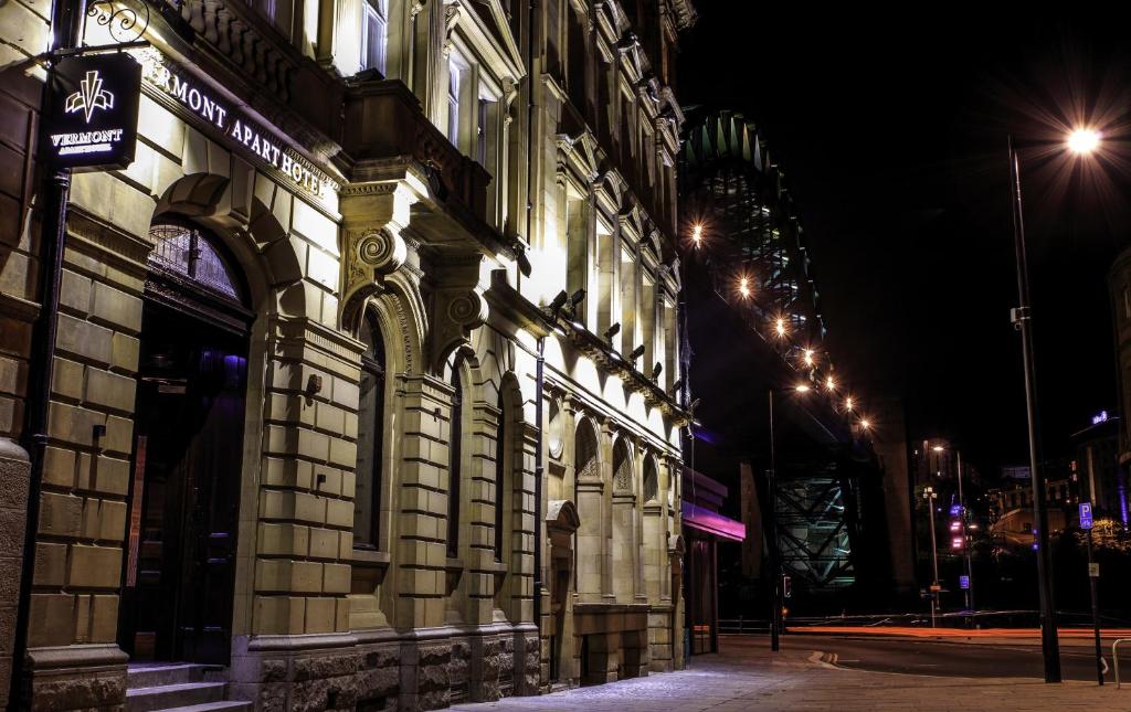 a building on a street at night with lights at The Vermont ApartHotel in Newcastle upon Tyne