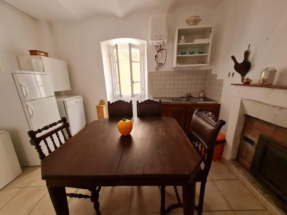una cocina con una mesa de madera con una naranja. en L'alive, en Feliceto