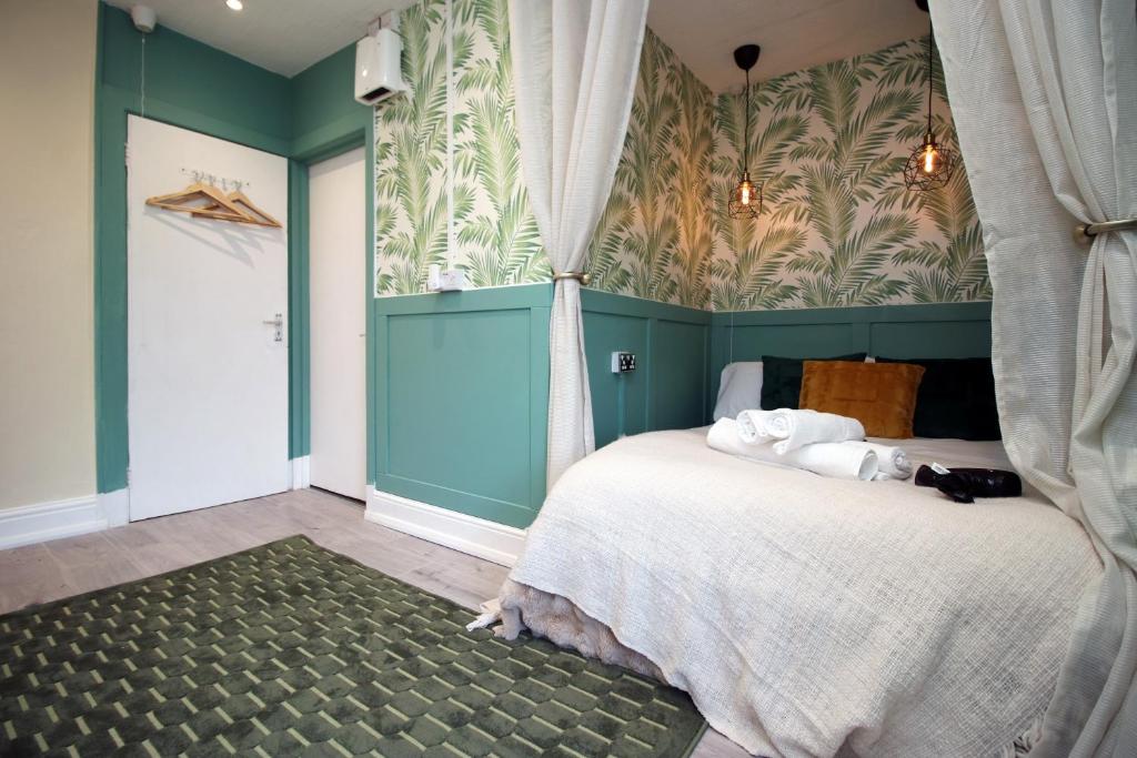 a bedroom with a bed with a green wall at Studio Apartment 5 mins walk to city, FREE WIFI AND PARKING in Cardiff