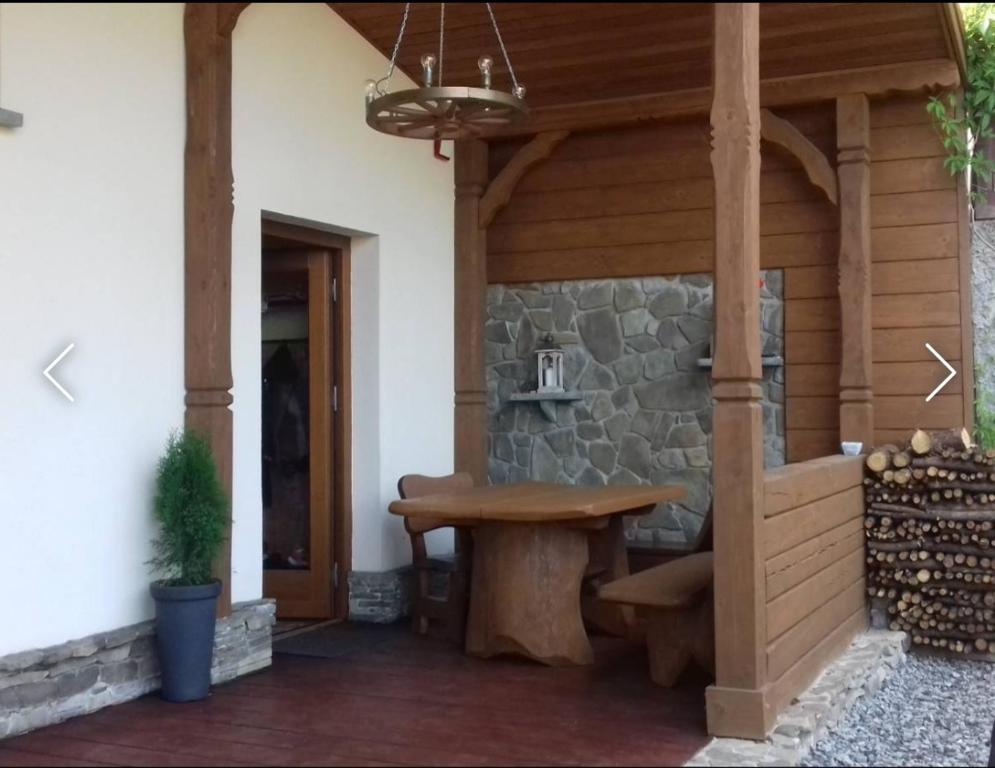 un patio con una mesa de madera y una pared de piedra en Chata pod Bieniatką, en Szczyrk