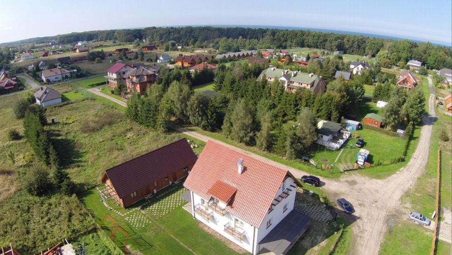 a large house with a red roof on a field at Dom Gościnny Agata in Mielenko