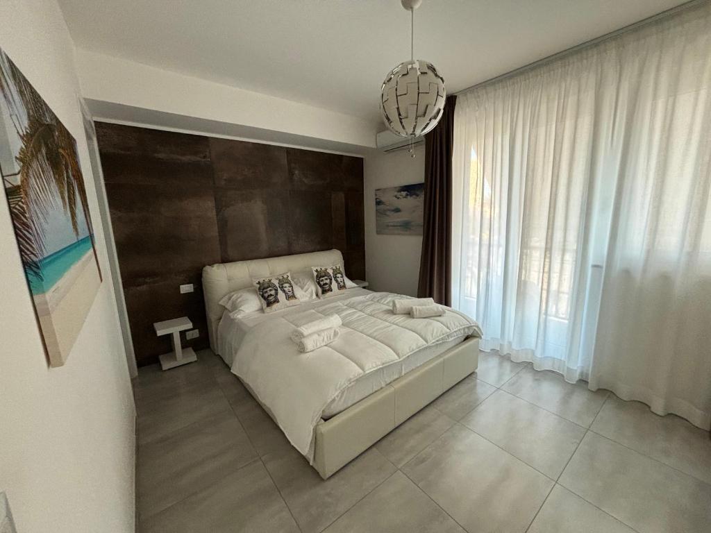 ein Schlafzimmer mit einem großen Bett und einem großen Fenster in der Unterkunft Appartamento Suite Galatea in Pozzallo