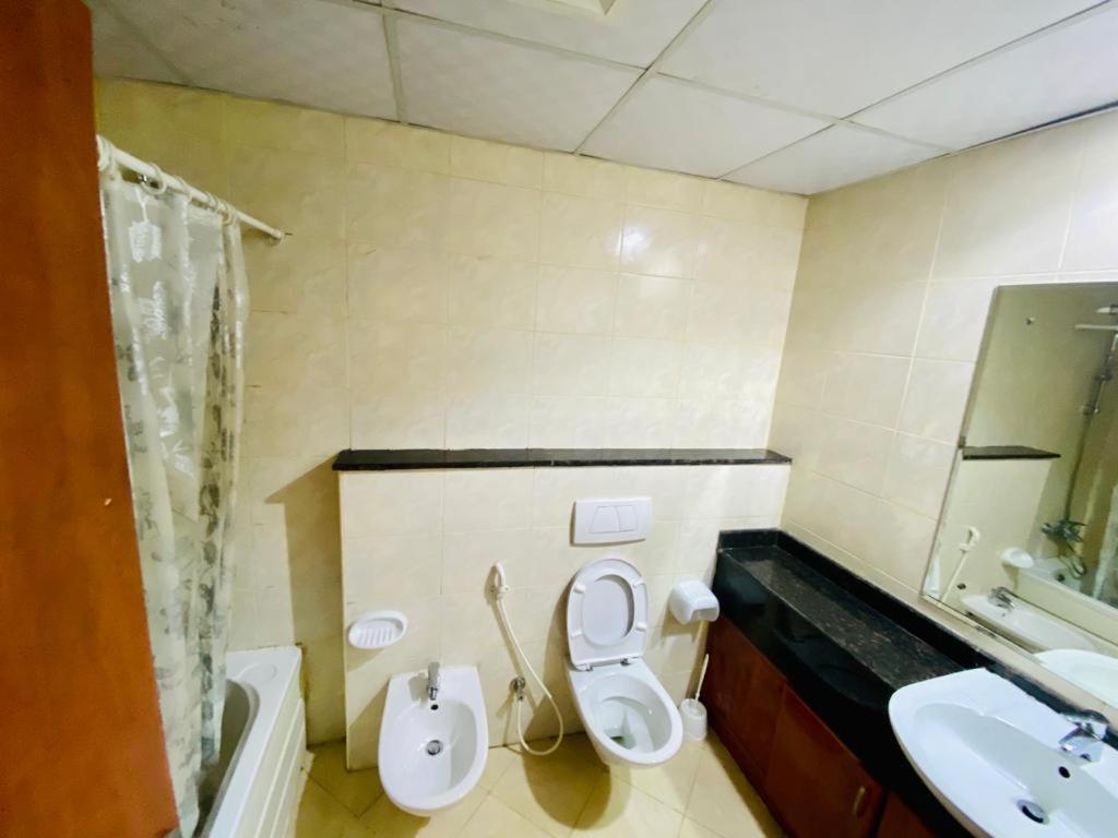 a bathroom with a toilet and a sink at Amazing PRIVATE ROOM 7 MIN FROM METRO MURPHY BED TV FRIDGE in Dubai