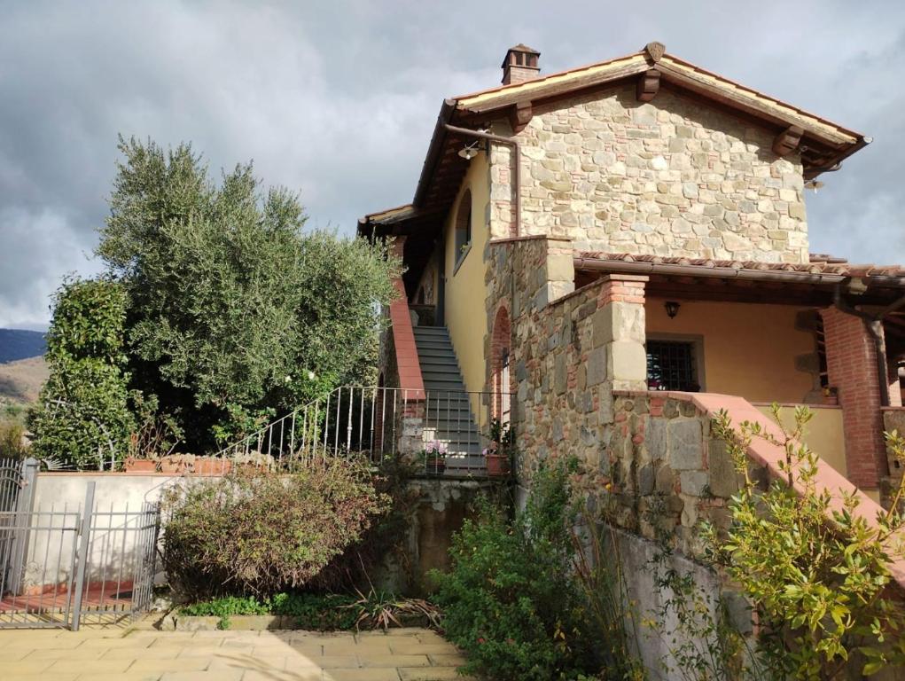 a stone house with a fence in front of it at Appartamento Olivella in Reggello