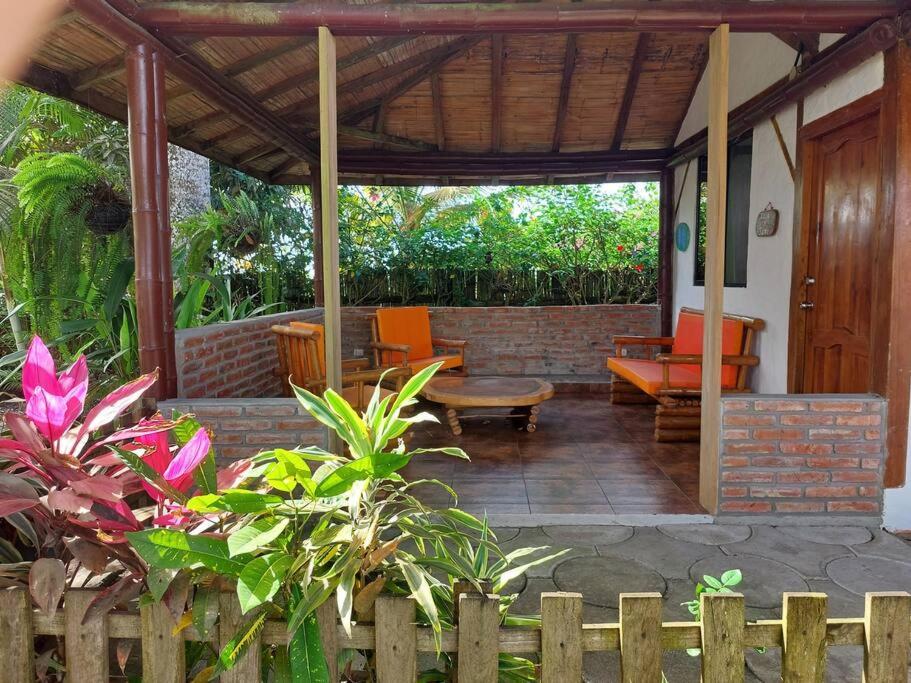 an outdoor patio with orange chairs and a brick wall at Casa SAMI Acepto Mascota in Ayampe
