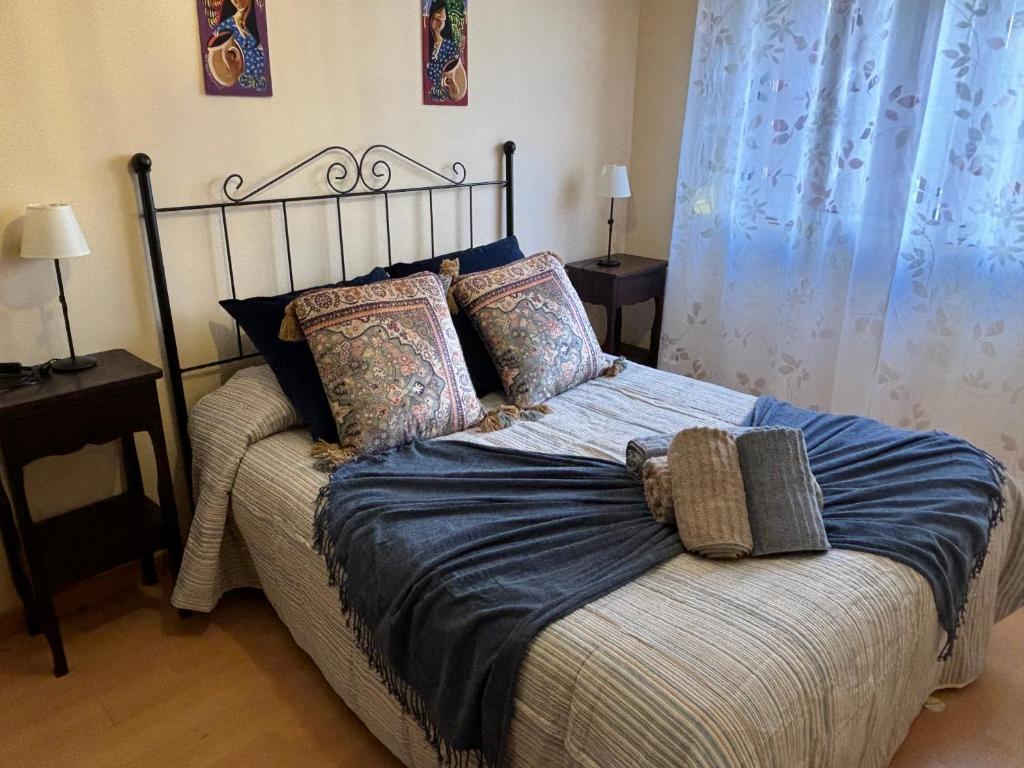1 dormitorio con 1 cama con sábanas y almohadas azules en Apartamento Ideal, en Madrid