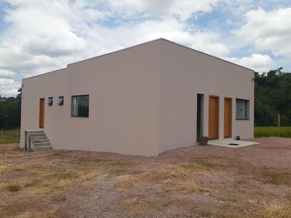 a large white building with a yard at Suítes Flor do Maracujá 02 in Ponta Grossa