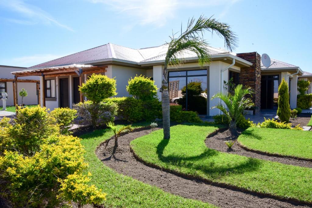 une maison avec un palmier dans la cour dans l'établissement Menucha Country Lodge, à Mthatha