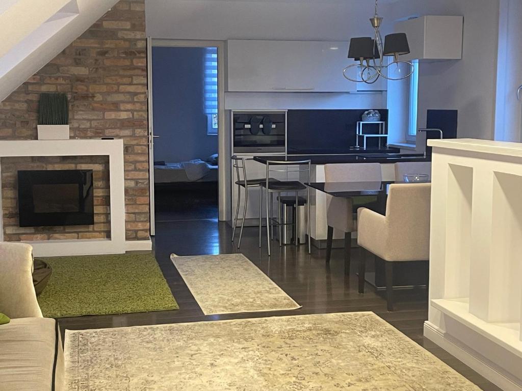 cocina y sala de estar con sofá y chimenea en Downtown Luxury apartman, en Szentendre