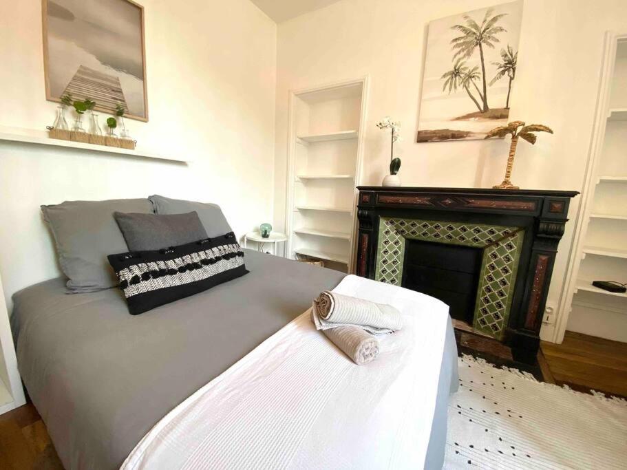 - une chambre avec un grand lit et une cheminée dans l'établissement Charmant studio au calme proche centre ville, à Rennes
