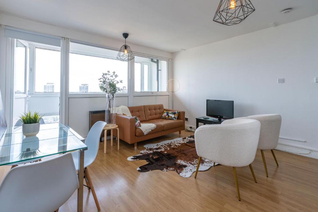 a living room with a couch and a table and chairs at City View Apartments - Bow in London