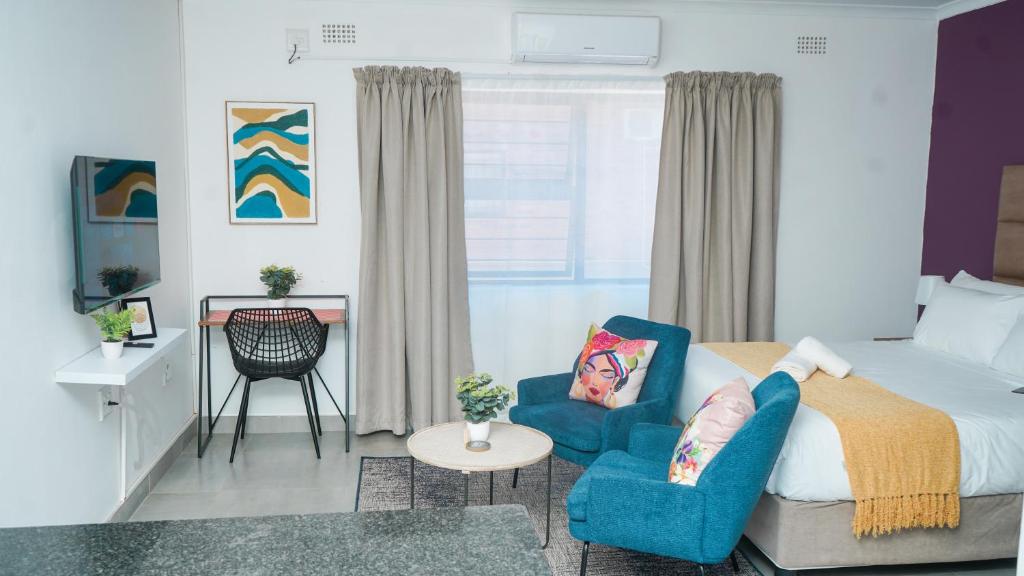 1 dormitorio con 1 cama, 1 silla y 1 mesa en Omi’s Wholesome Apartment, en Mthatha