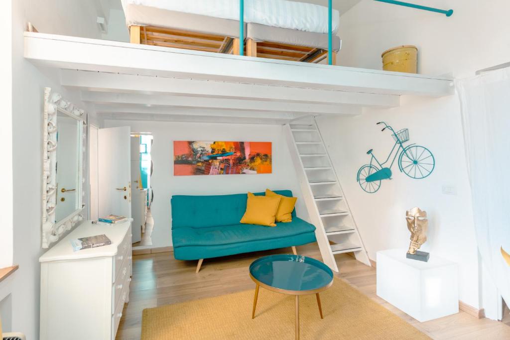 uma sala de estar com um sofá azul e uma cama alta em Babuino Mini Loft em Roma