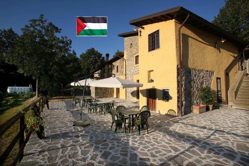 Bandera ondeando sobre un patio con mesas y sillas en B&B Podere Bramapane, en Montelungo Superiore